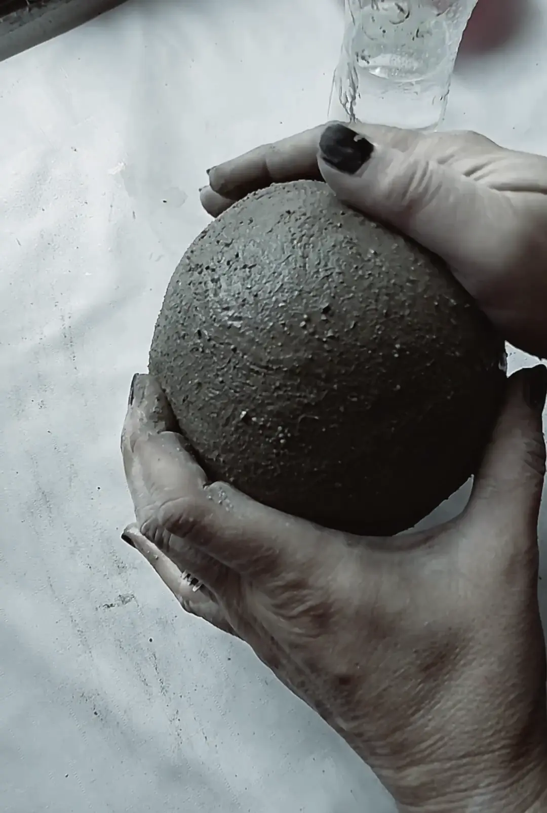 Hands holding a 53 Design Lab concrete piece during the making process